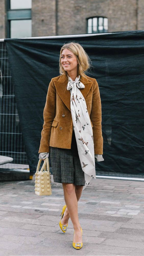 a Parisian chic look with a grey plaid knee skirt, a mustard corduroy blazer, yellow embellished shoes, a scarf and a beaded bag
