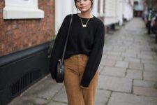 a black jumper, a statement necklace, tan cropped corduroy trousers, a black round bag and boots