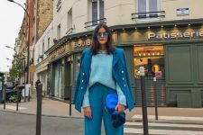 a bold blue pantsuit, a light blue jumper, white sneakers, an electric blue bag and blue sunglasses