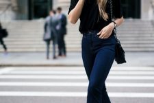 a bold fall outfit wiht a black t-shirt, dark blue flare jeans, black lace up shoes and a black bag