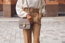a classy fall work look with a white jumper, tan high waisted trousers with a belt, orange shoes and a grey crossbody bag