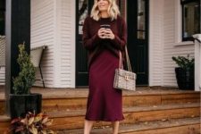 a cozy and girlish look with an oversized burgundy sweater, a slip skirt, heels, a snakeskin print bag