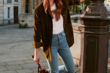 a fall-toned look with a white tee, blue jeans, a mustard-colored velvet blazer, a burgundy bag and booties