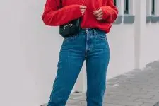 a hot red sweater, blue slim leg jeans, white sneakers, a black bag and layered necklaces