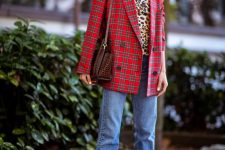 a leopard print turtleneck, a red plaid oversized blazer, blue jeans, red strappy shoes and a reptile print bag