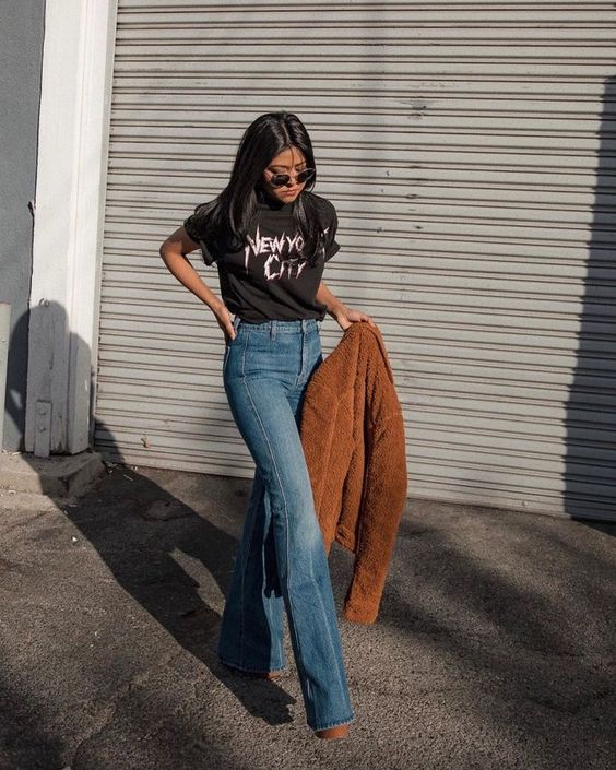 a lovely fall look with a black t shirt, blue flare jeans, a brown faux fur coat and brown boots is relaxed
