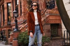 a lovely fall outfit with a white turtleneck, blue jeans, a rust-colored corduroy blazer, a black bag and black sock boots