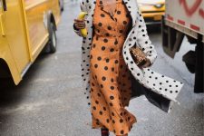 a lovely girlish look with a rust-colored polka dot shirtdress, a white polka dot coat and black sneakers with pink laces