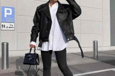 a monochromatic look with an oversized white shirt, black skinnies, black boots, a black leather jacket and a small bag