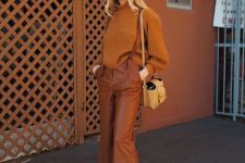 a pretty and comfortable outfit with a rust-colored sweater, leather trousers, mules, a tan bag is a stylish idea
