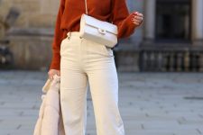 a rust-colored jumper, white cropped jeans, snakeskin print Chelsea boots, a white bag and a faux fur coat