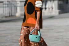 a rust-colored polka dot sweater, a brown polka dot slip skirt, white kitten heels and a blue bag for the fall