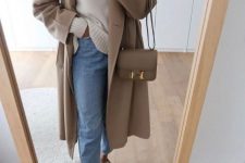 a simple casual fall outfit with a white jumper, blue jeans, tan loafers, a tan coat and a tan crossbody bag