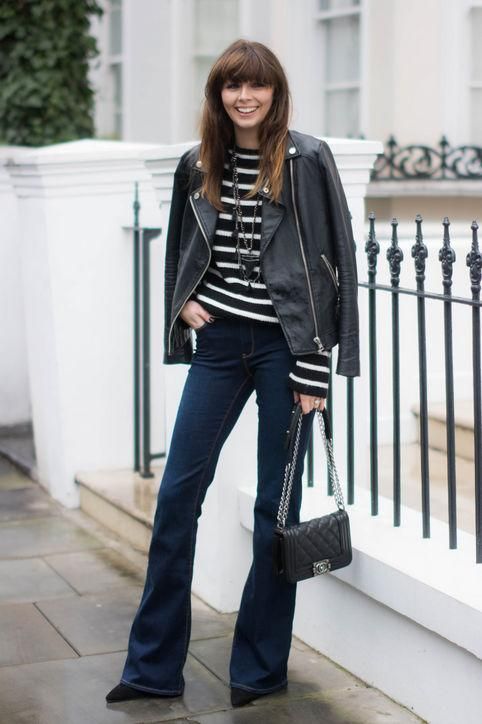 a striped black and white top, a black leather jacket, navy jeans, black boots and a black bag