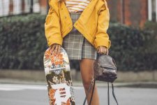 a striped t-shirt, a grey plaid wrap mini skirt, white trainers and striped socks, a yellow denim jacket and a backpack