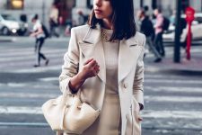 a stylish neutral look with a top, trousers, a coat and a pretty small bag that makes a statement with its shape