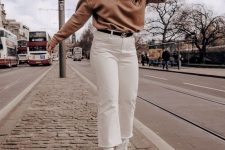 a tan sweatshirt, white jeans, a black logo belt, white sneakers are a simple and very stylish work look