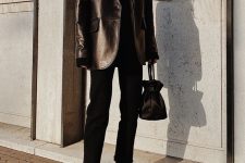 a total black outfit with a turtleneck, jeans, boots, a leather blazer and a small bag is cool