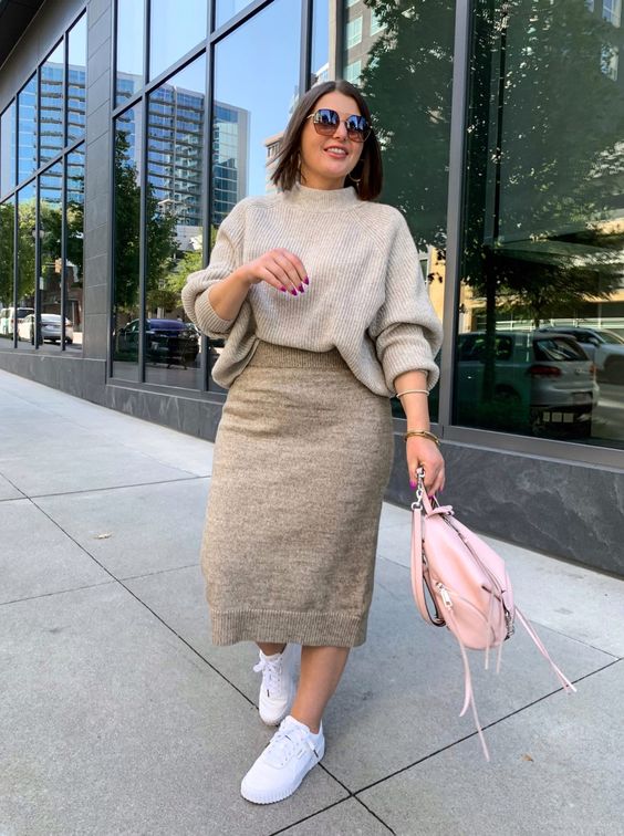 a very comfy and minimal flal work look with a grey turtleneck sweater, a tan midi skirt, white sneakers and a pink bag