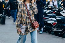 a very trendy look with a white t-shirt, blue flare jeans, yellow booties, a bright yellow plaid oversized blazer, a burgundy bag