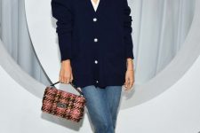 awhite lace shirt, an oversized navy cardigan, blue jeans, lace up booties and a printed bag