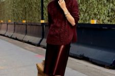 06 a burgundy turtleneck sweater, a shiny vinyl skirt, black shoes and a tan tote for work