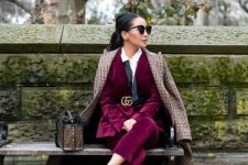 08 a chic work outfit with a burgundy velvet pantsuit, pink shoes, a white shirt, a black belt and a plaid coat