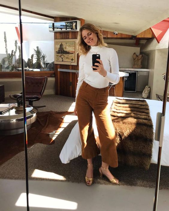 a white turtleneck, mustard colored corduroy cropped pants, gold shoes and a delicate necklace for a comfy and chic look