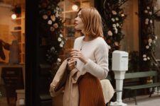 14 a white cashmere jumper, a rust-colored pleated midi skirt, a tan trench, a neutral bag for work in the fall