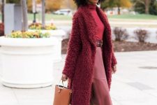 15 a monochromatic burgundy look with a turtleneck, a faux leather skirt, boots with heels and a tan bucket bag