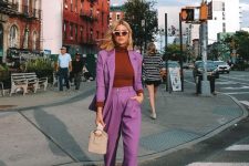 16 a fall work look with a purple pantsuit, a rust turtleneck, white heels and a tan bucket bag