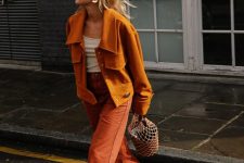 18 a bright fall outfit with a white top, a rust-colored shirt jacket, burnt orange jeans, burgundy boots, a bucket bag and statement earrings