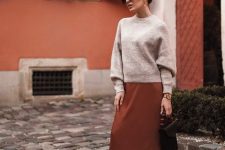 19 a neutral jumper, a rust-colored slip midi skirt, black boots, a black bag and statement earrings for a cool and bold look