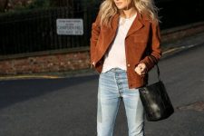 31 a white t-shirt, light blue jeans, black boots, a black woven bucket bag and a rust-colored jacket for a touch of color