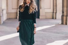With emerald pleated knee-length skirt, chain strap bag and ankle boots
