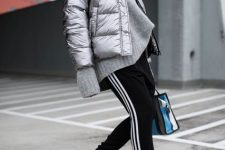 With gray oversized sweater, black and white sporty pants, black flat mules and colorful bag