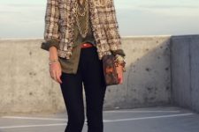 With olive green loose button down shirt, sunglasses, printed bag, golden necklace, skinny cropped pants, brown lace up ankle boots and red belt