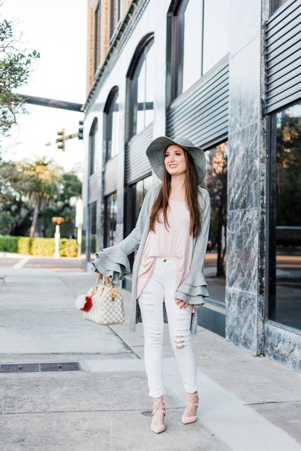 With pale pink loose shirt, printed bag, white distressed pants, lace up shoes and gray hat