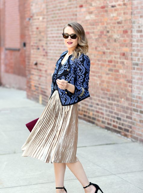 With top, metallic pleated midi skirt, purple clutch and black shoes