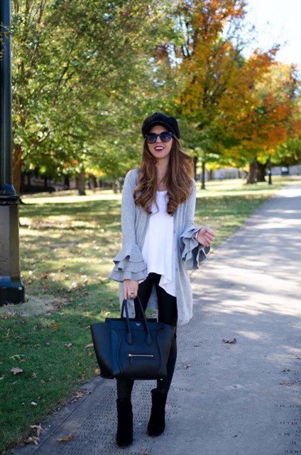 With white long blouse, black cap, black leggings, tote bag and heeled boots