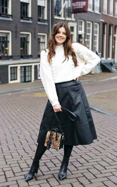With white oversized sweater, leopard printed tassel bag and black boots