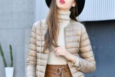 With white turtleneck sweater, black wide brim hat and brown leather belted skirt