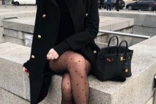 a black mini dress, combat boots and pritned tights, a black knee coat and a black bag for a girlish look