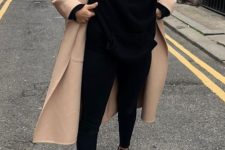 a black oversized hoode, black leggings, black sneakers, a tan coat for a cool and sport chic look for every day