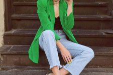 a black top, blue jeans, a bold green long blazer, green slingbacks for a creative work look