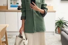a chic work outfit with a white pleated midi skirt, a green shirt jacket, green socks, man style shoes and a neutral bag