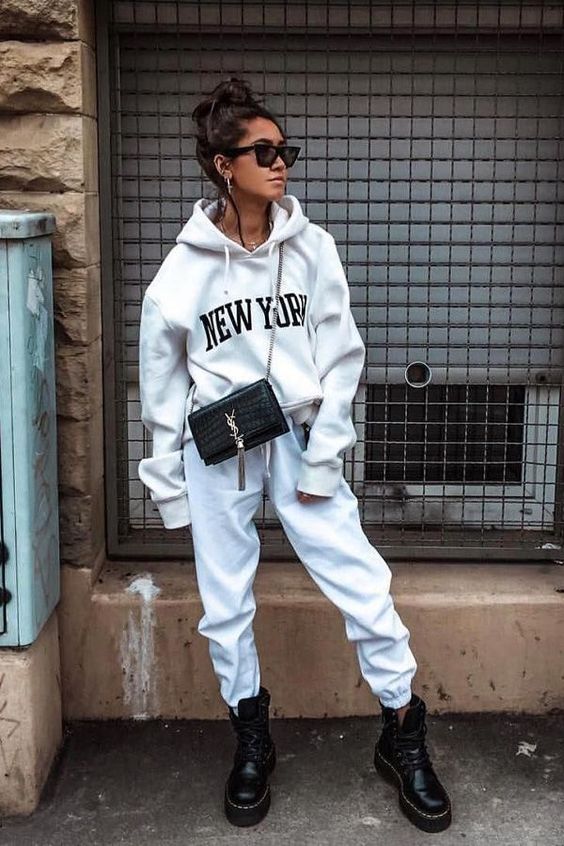a creamy hoodie and sweatpants, black combat boots, a black bag and statement earrings for a simple fall look