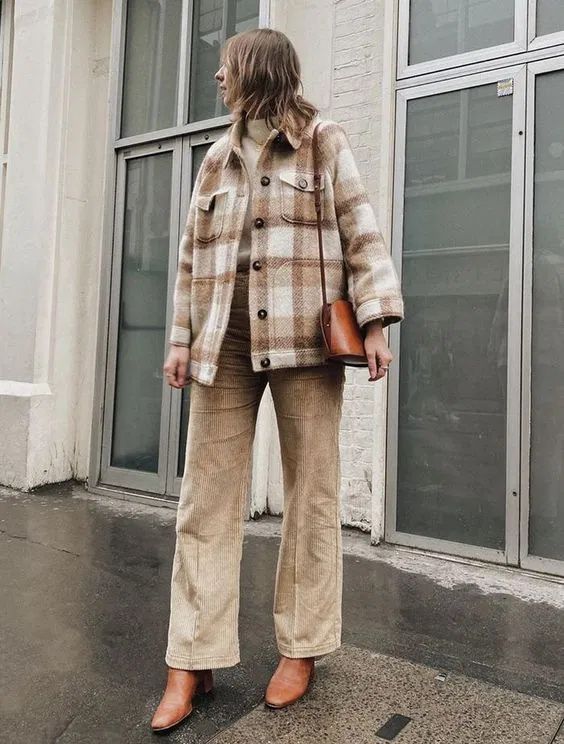 a creamy sweater, a neutral plaid shirt jacket, tan corduroy trousers, brown boots and a brown bag