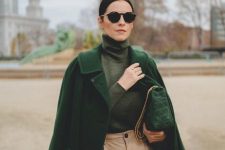 a muted grene turtleneck, an emerald coat, tan pants, a green bag to rule the fall colors
