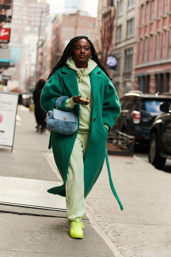 a neon green hoodie and sweatpants, neone yellow sneakers, an emerald coat and a black faux fur bag for a statement